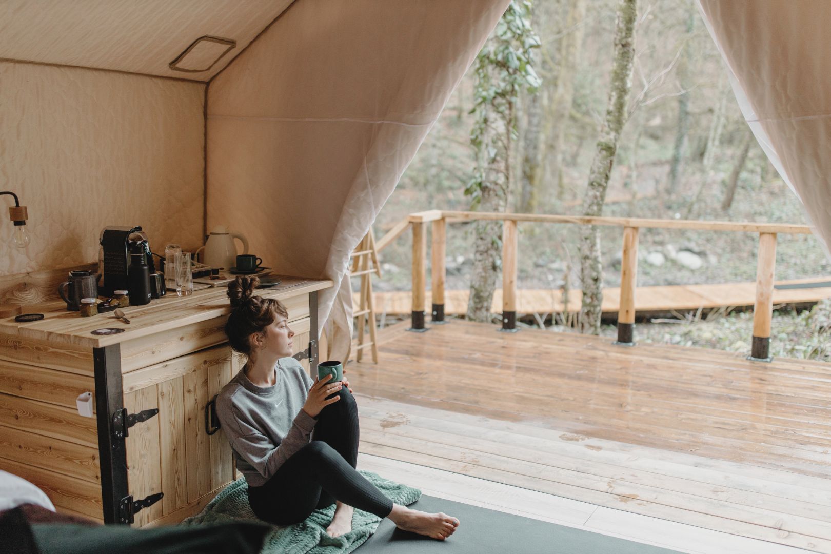 Woman sitting in a glamping tent thinking how to start a glamping business